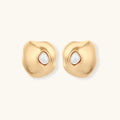 Organic-shaped eco-zinc alloy stud earrings with resin pearl centers and sterling silver posts on white background.