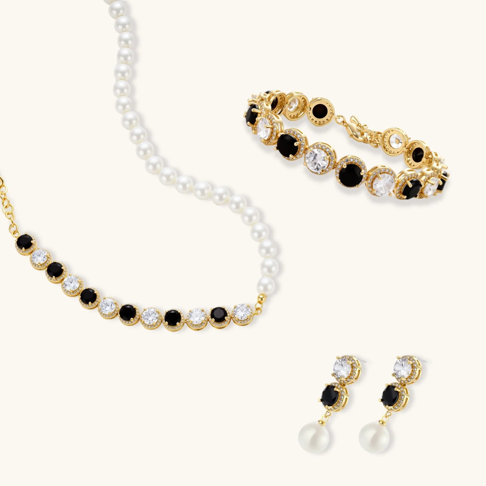 Gold-plated jewelry set with alternating black and clear cubic zirconia stones, featuring necklace, earrings and bracelet