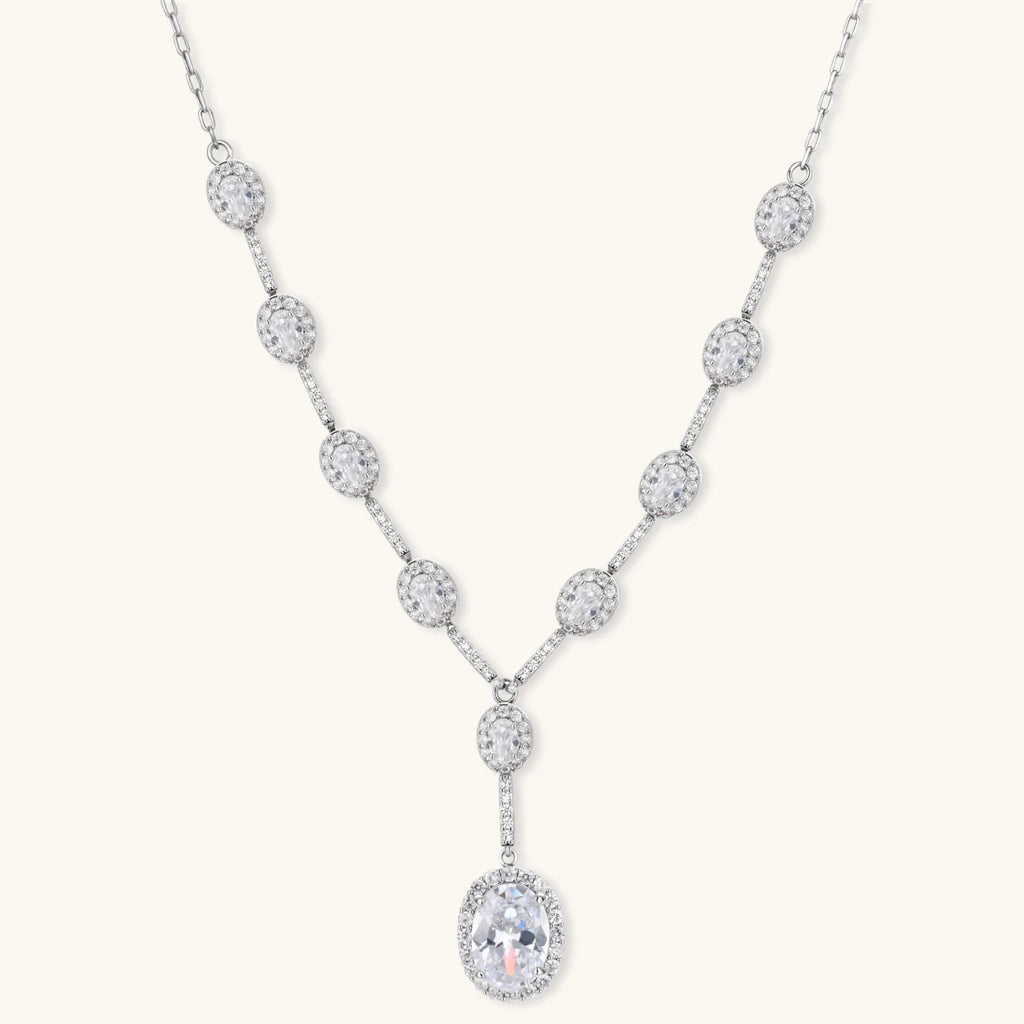Elegant white gold plated jewelry set with oval cubic zirconia stones in halo settings, featuring Y-necklace and drop earrings.