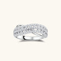 Sterling silver crossover ring with pavé-set moissanite stones creating an elegant infinity design on neutral background