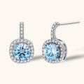 Sterling silver drop earrings featuring cushion-cut blue moissanite stones surrounded by sparkling halo settings