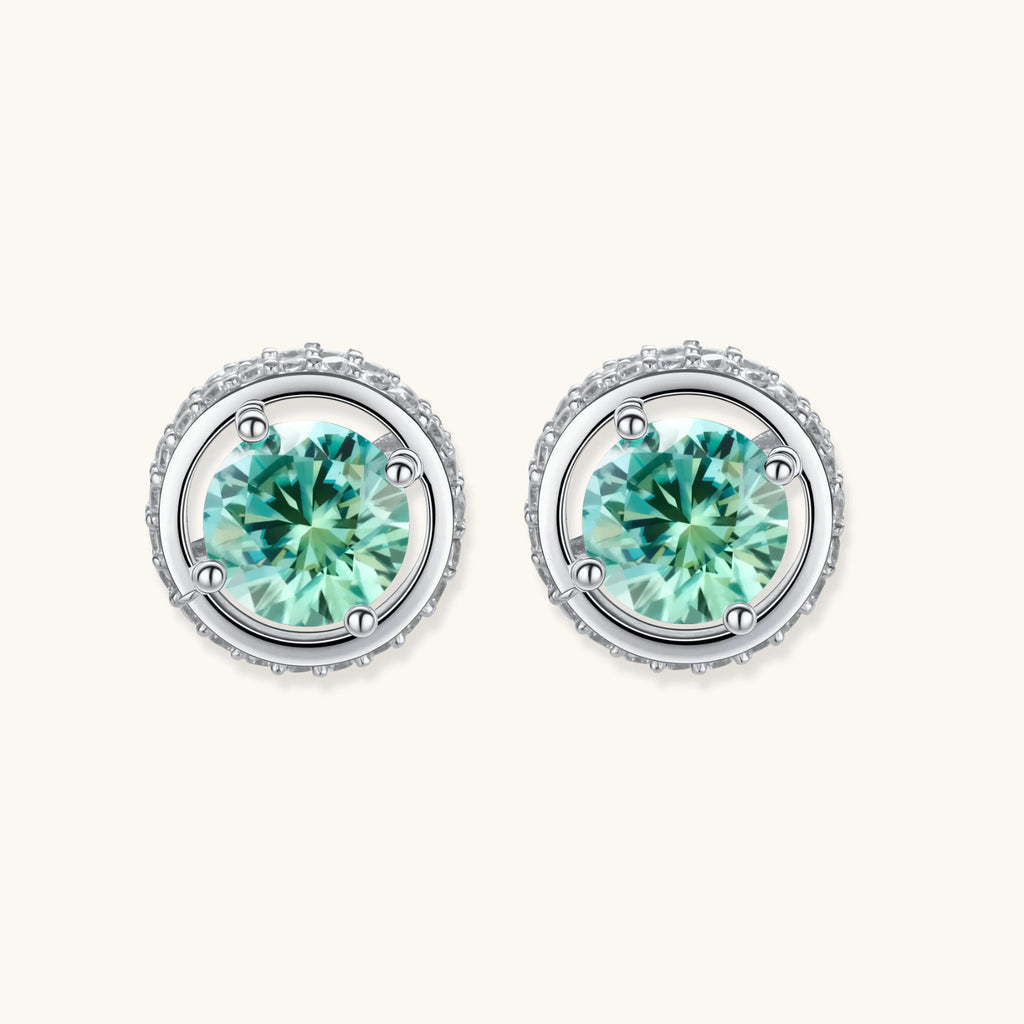 Round green moissanite stud earrings in sterling silver halo settings with brilliant sparkle on white background.