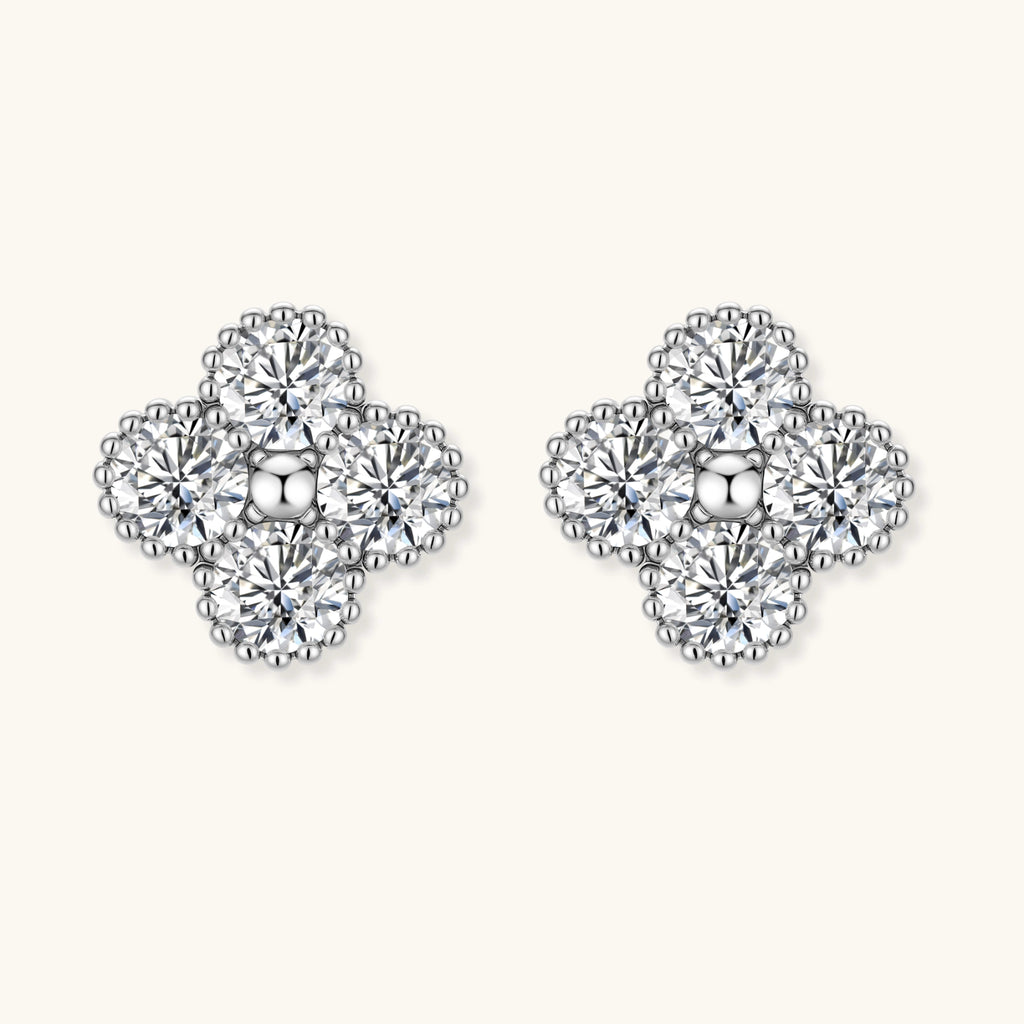 Dainty sterling silver quatrefoil stud earrings with four brilliant moissanite stones and center accent on white background.