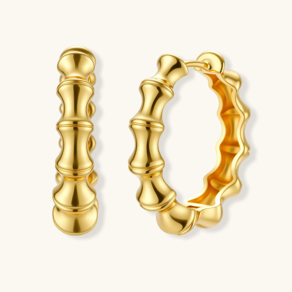 Close-up of gold-plated sterling silver hoop earrings with bamboo-inspired segmented design on white background.
