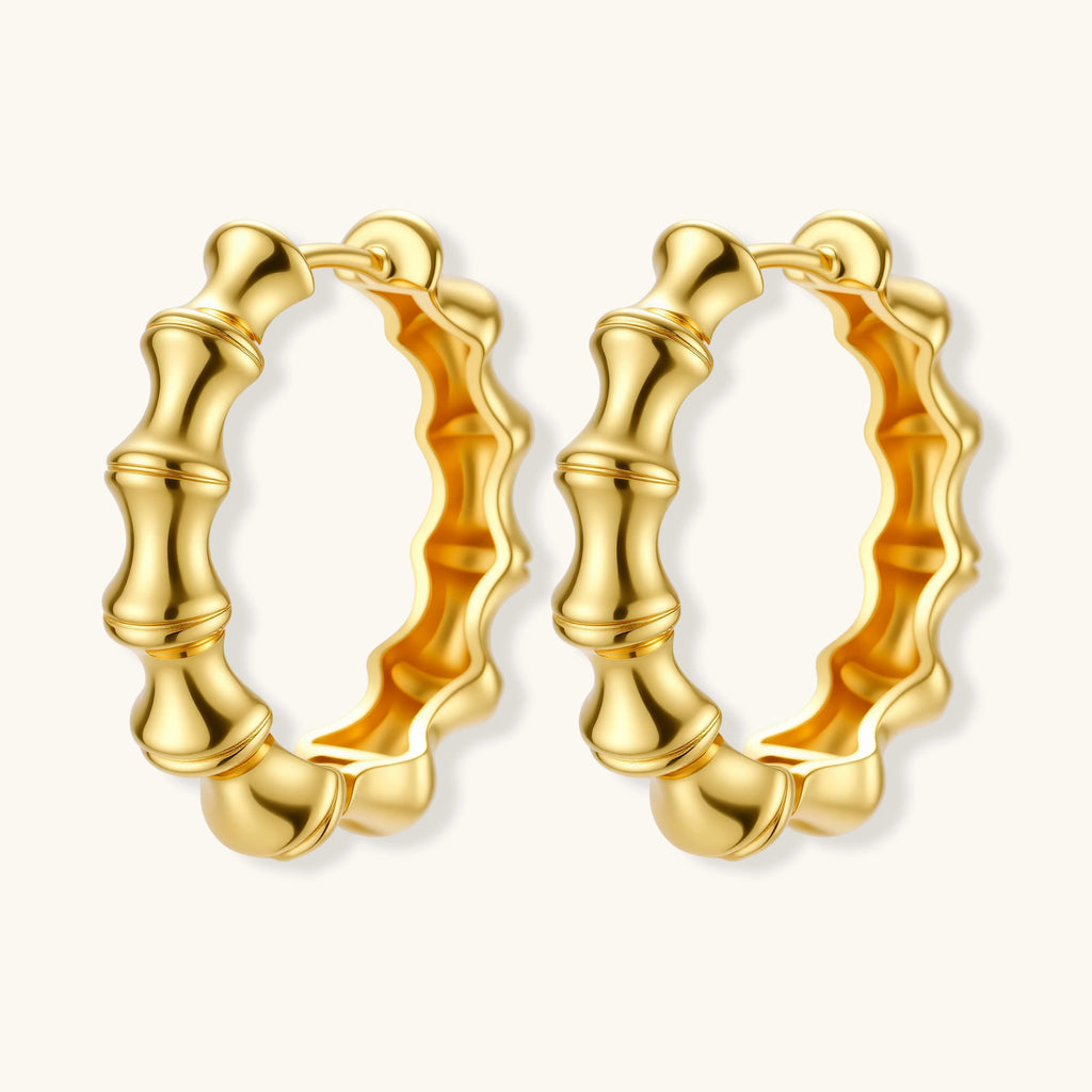 Close-up of gold-plated sterling silver hoop earrings with bamboo-inspired segmented design on white background.