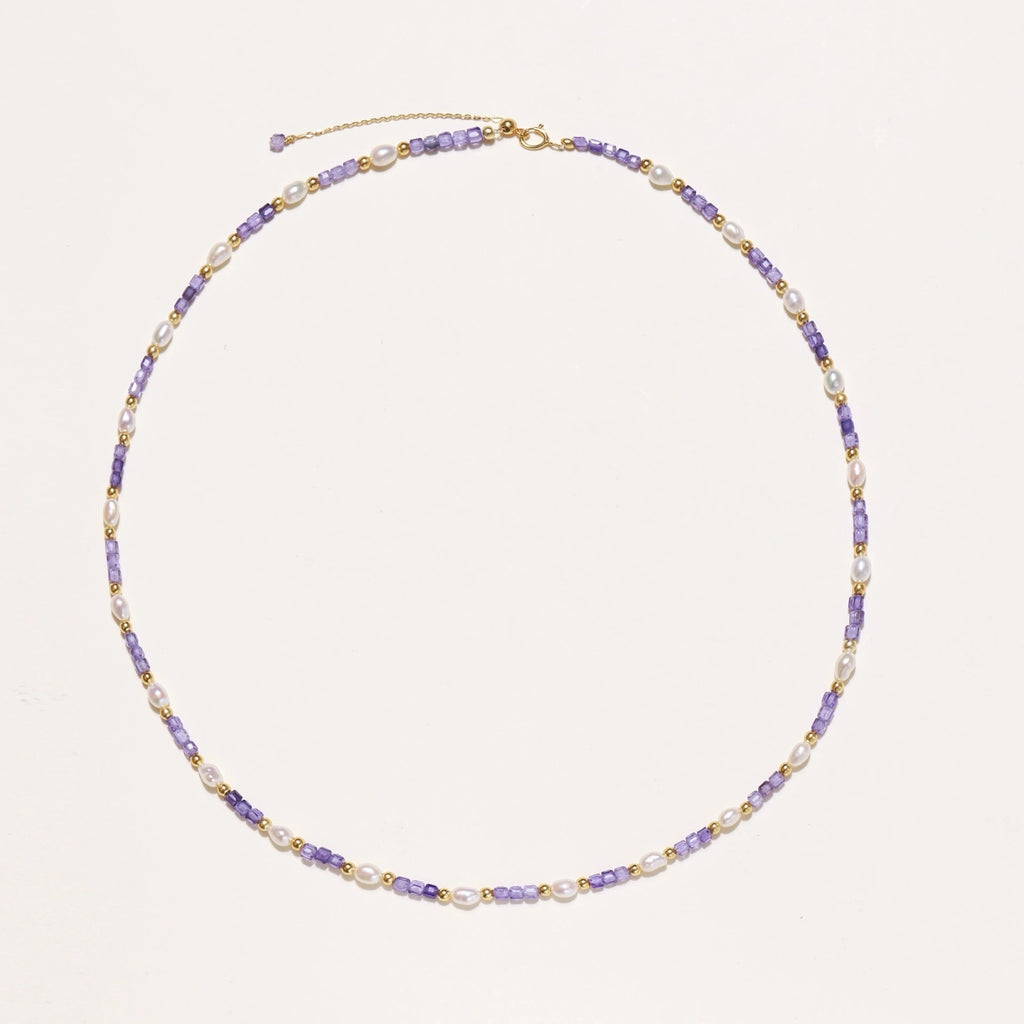 Delicate 18K gold vermeil necklace with alternating lavender zirconia beads and white freshwater pearls on cream background