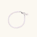 Adjustable bracelet featuring lustrous freshwater pearls with rhodium-plated sterling silver clasp on cream background.