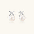 Rhodium-plated silver stud earrings with sparkling X design above lustrous round freshwater pearls on white background.