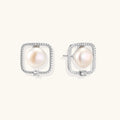 Rhodium-plated silver stud earrings with cushion frame, centered freshwater pearl, and tiny crystal accent