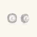 Rhodium-plated sterling silver stud earrings with round freshwater pearls surrounded by geometric crystal halos on cream background.
