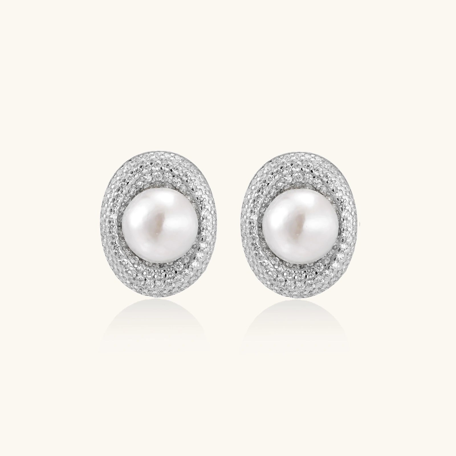 Elegant stud earrings with cream freshwater pearls surrounded by sparkly pavé crystals on rhodium-plated silver setting