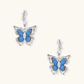 Silver hoop earrings with blue denim butterfly charms outlined in barbed wire design and central zirconia stone