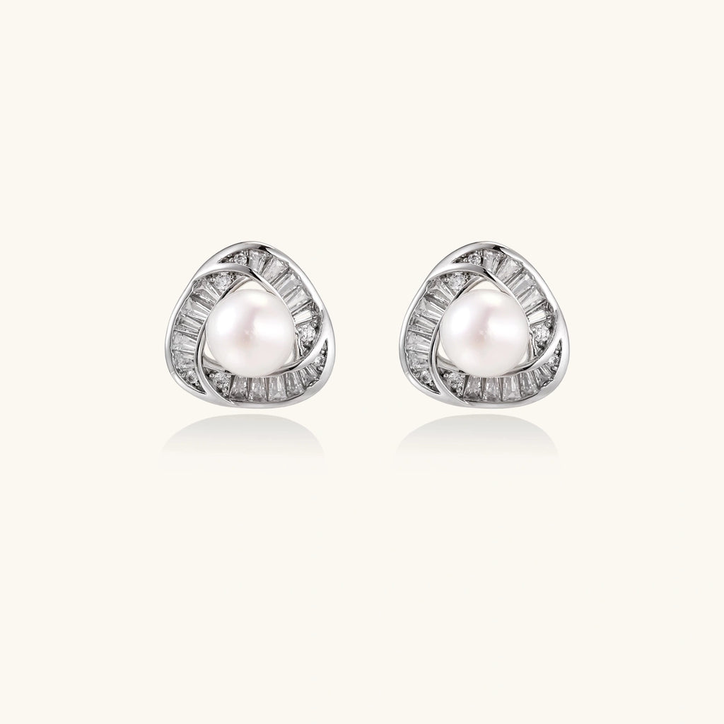 Triangular white gold plated stud earrings with central freshwater pearl and baguette-cut stones on white background