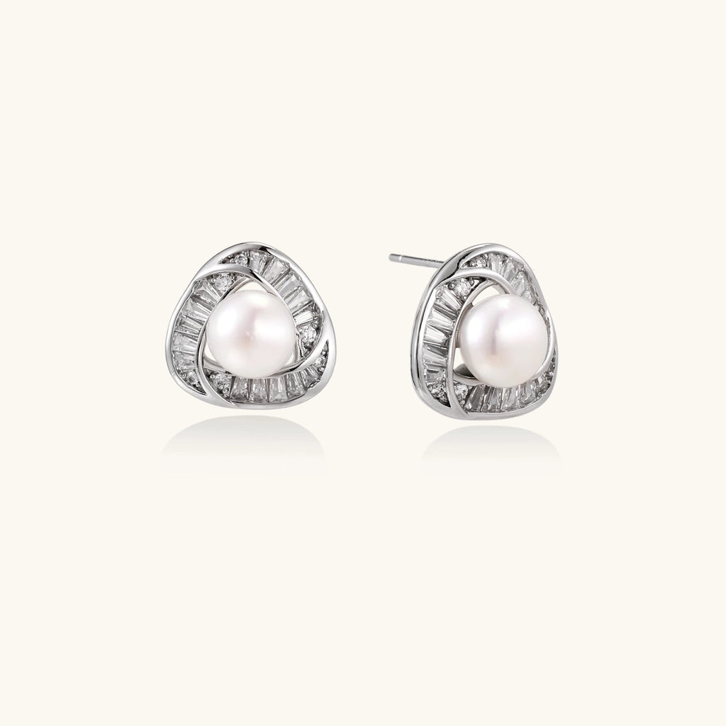 Triangular white gold plated stud earrings with central freshwater pearl and baguette-cut stones on white background