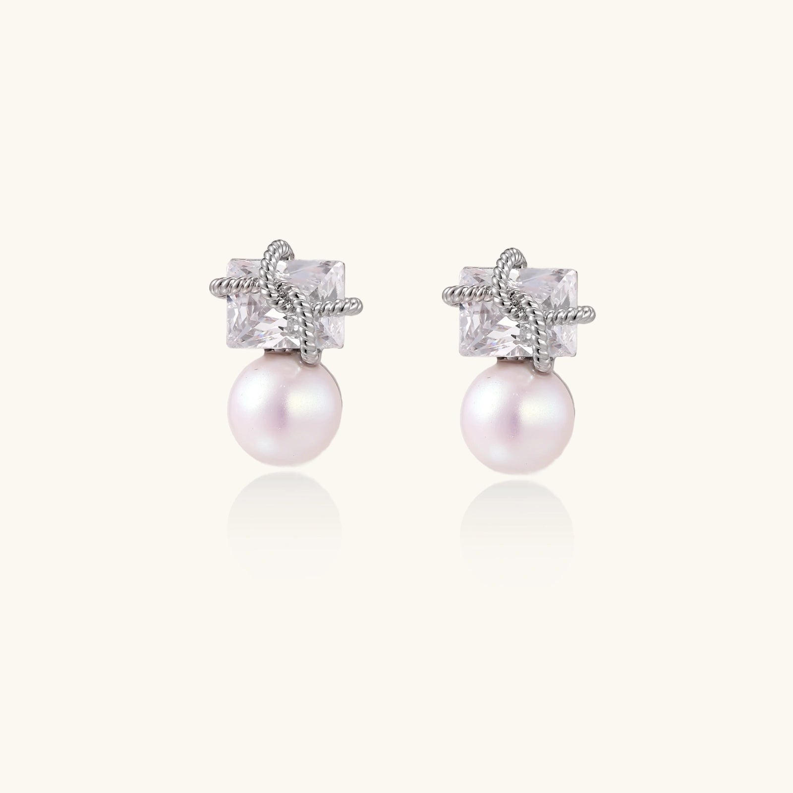 White gold stud earrings with square crystal stones in twisted frames and pink freshwater pearl drops below