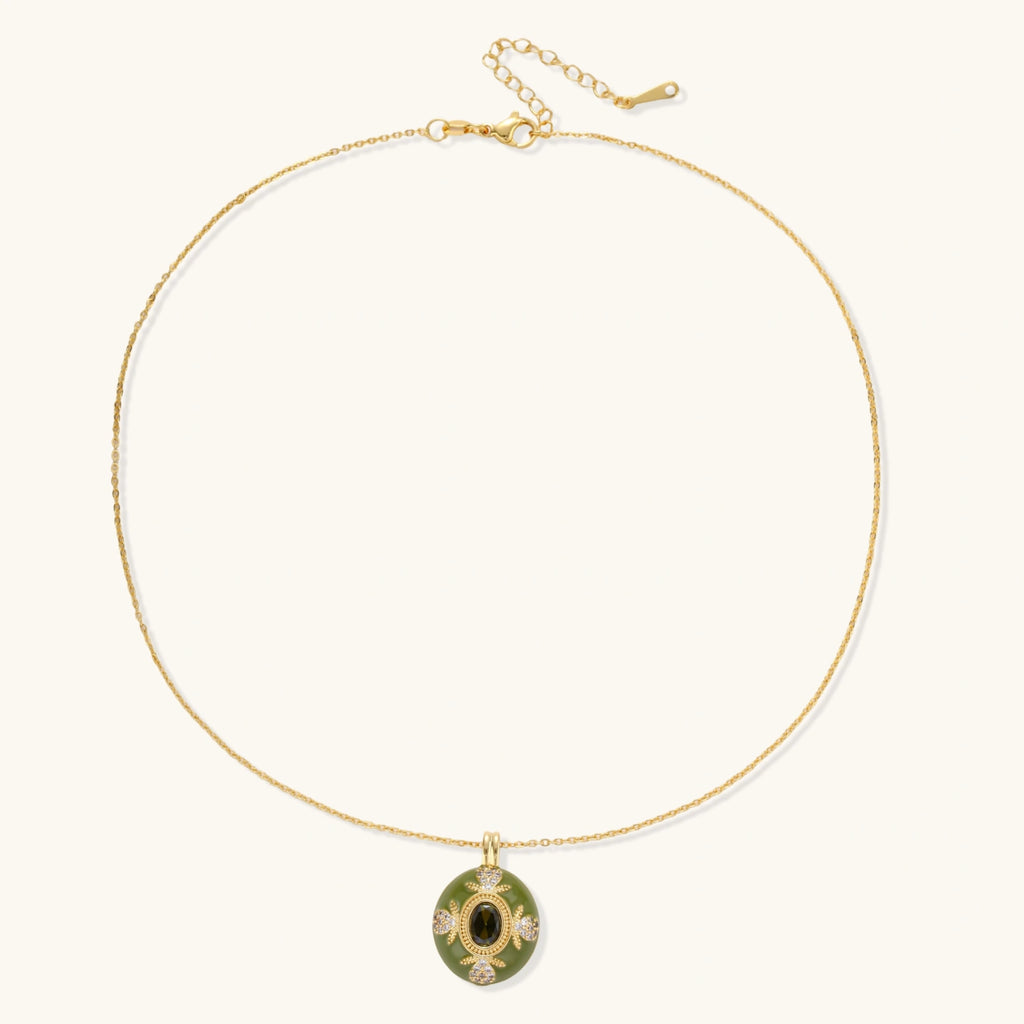 Gold-plated pendant necklace with green enamel background and oval olive cubic zirconia center stone with crystal accents.